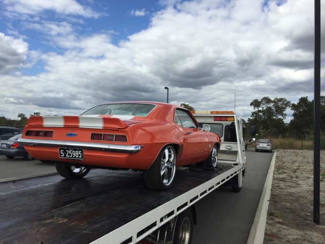 orange corvette being towed in Perth by a tilt tray